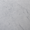 Polished Carrara marble slab with cool white background and fine grey veining on a black display stand