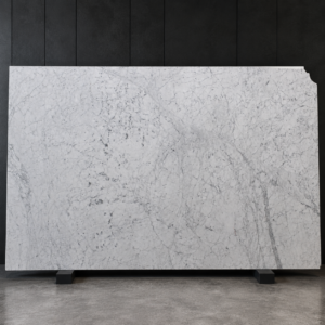 Polished Carrara marble slab with cool white background and fine grey veining on a black display stand