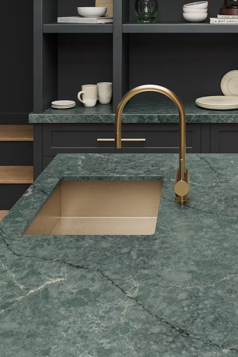 Jardin Emerald Silestone green quartz countertop with pale veining, a brass sink and dark cabinetry