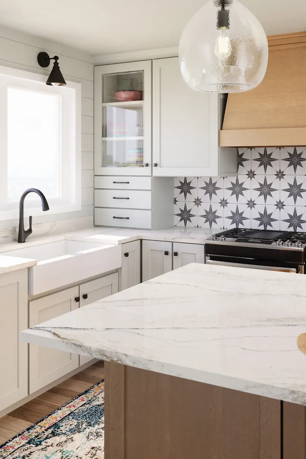 Lakedale Cambria quartz island in a white farmhouse kitchen with a star-patterned backsplash and apron sink