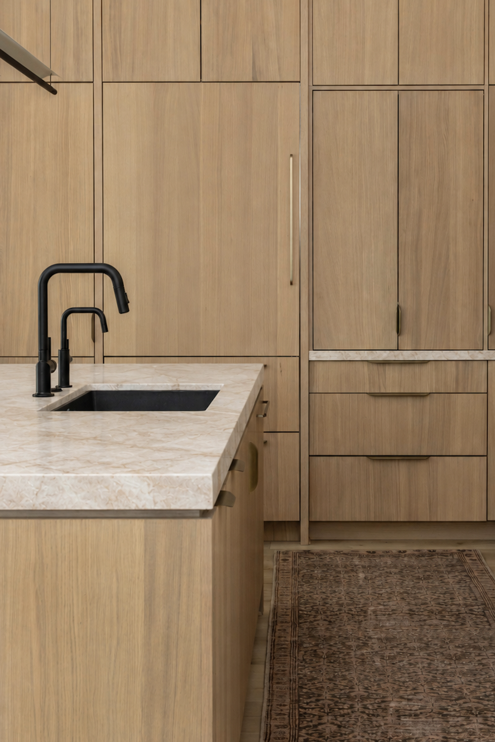 Taj Mahal quartzite countertops in a white kitchen with iron lantern pendants and two islands